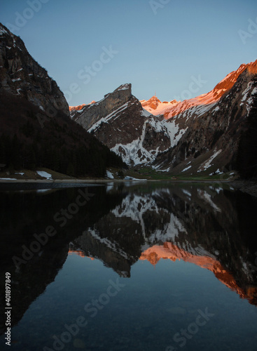 Reflection of Saentis mountain range in alpine lake Seealpsee in Alpstein Appenzell alps Innerrhoden Switzerland photo