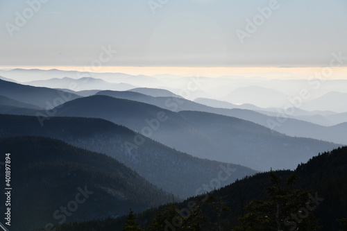 Spectacular view of mountain ranges silhouettes and fog in valleys during sunset time at Stowe  Vermont  USA