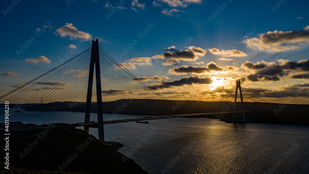 The image of the Yavuz Sultan Selim Bridge, taken at sunset under the cloudy sky