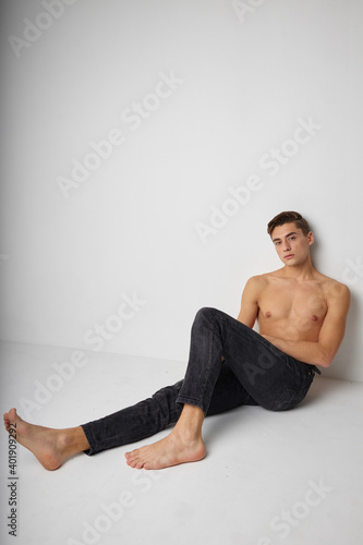 Man sitting on floor naked torso posing isolated background