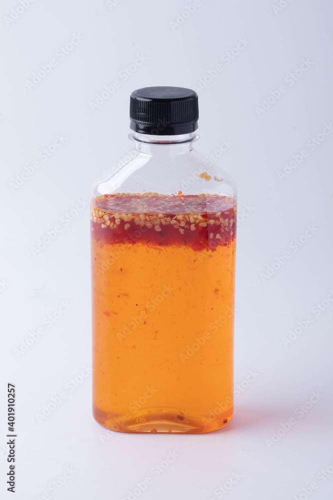 Chicken dipping sauce in a bottle made from sweet hot chili on white background. Chicken dipping sauce in a bottle made from sweet hot chili on white background.