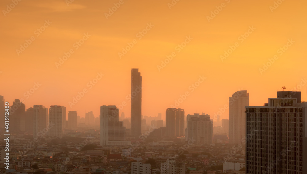 Air pollution in Bangkok, Thailand. Smog and fine dust of pm2.5 covered city in the morning with orange sunrise sky. Cityscape with polluted air. Dirty environment. Urban toxic dust. Unhealthy air.