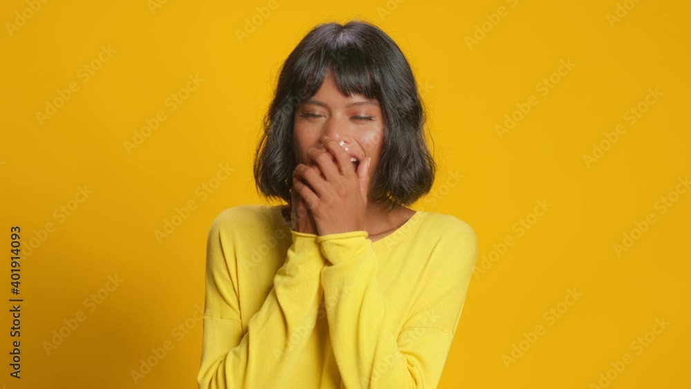 Shocked young dark skinned woman covers mouth with hands reacts on astonishing news cheers something raises hands and feels very happy to win or hear something pleasant isolated on yellow background Shocked young dark skinned woman covers mouth with hands reacts on astonishing news cheers something raises hands and feels very happy to win or hear something pleasant isolated on yellow background