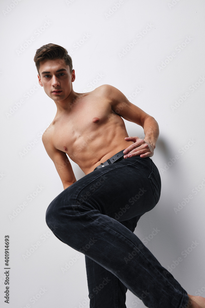 A man in trousers with a raised leg and a naked torso bottom view A man in trousers with a raised leg and a naked torso bottom view