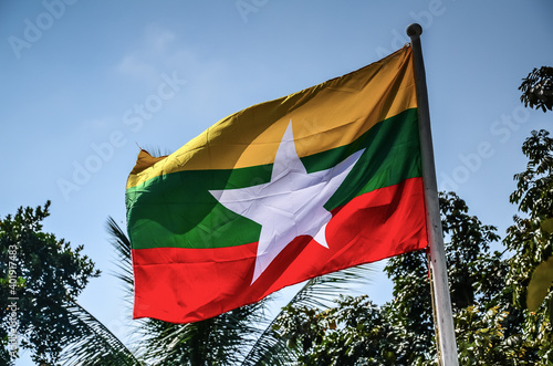 Myanmar flag waving on blue sky background photo