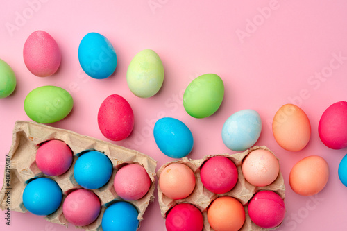 Painted Easter eggs on pink background top view