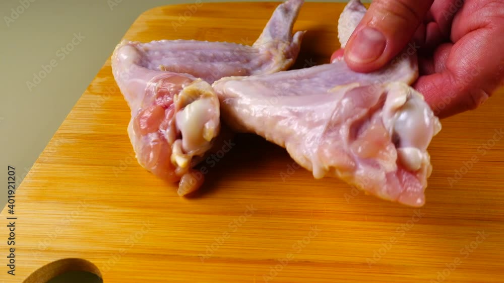 Fresh chicken wings are laid out on a cutting board. Fresh chicken wings are laid out on a cutting board.