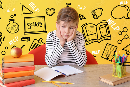 Sad little boy doing homewo...