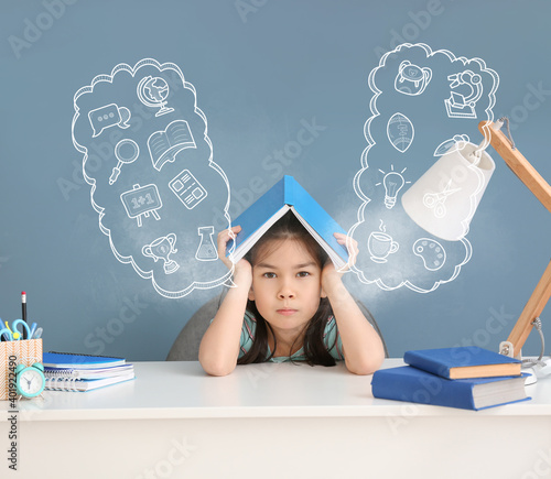 Stressed Asian girl doing homework at table