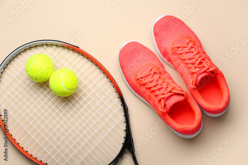 Sportive shoes, tennis racket and balls on light background © Pixel-Shot