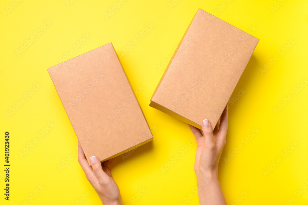 Hands with cardboard boxes on color background Hands with cardboard boxes on color background