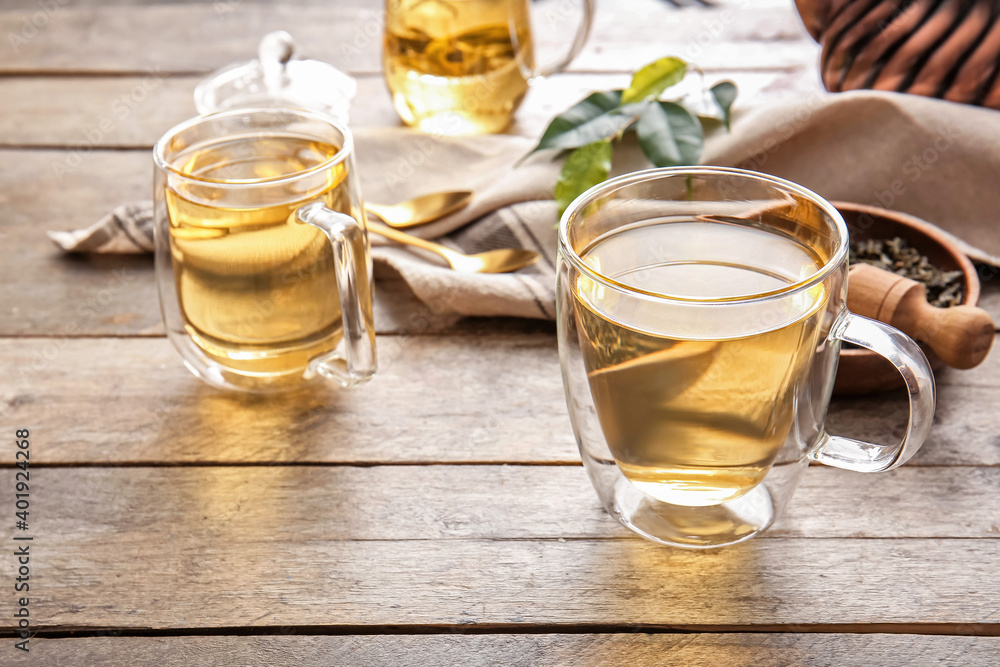 Composition with cups of green tea on wooden table Composition with cups of green tea on wooden table