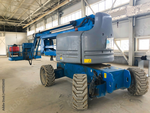 Manlifting vehicle inside industrial building. Man lifting platform machinery