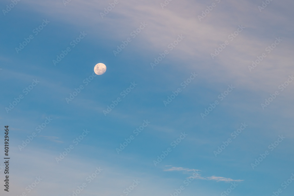 The Moon and White and Blue High Clouds in the Sky at Sunset The Moon and White and Blue High Clouds in the Sky at Sunset