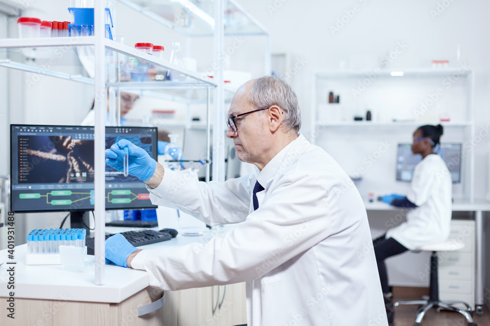 Senior scientist and african assistant working together in modern laboratory. Viorolog researcher in professional lab working to discover medical treatment. Senior scientist and african assistant working together in modern laboratory. Viorolog researcher in professional lab working to discover medical treatment.