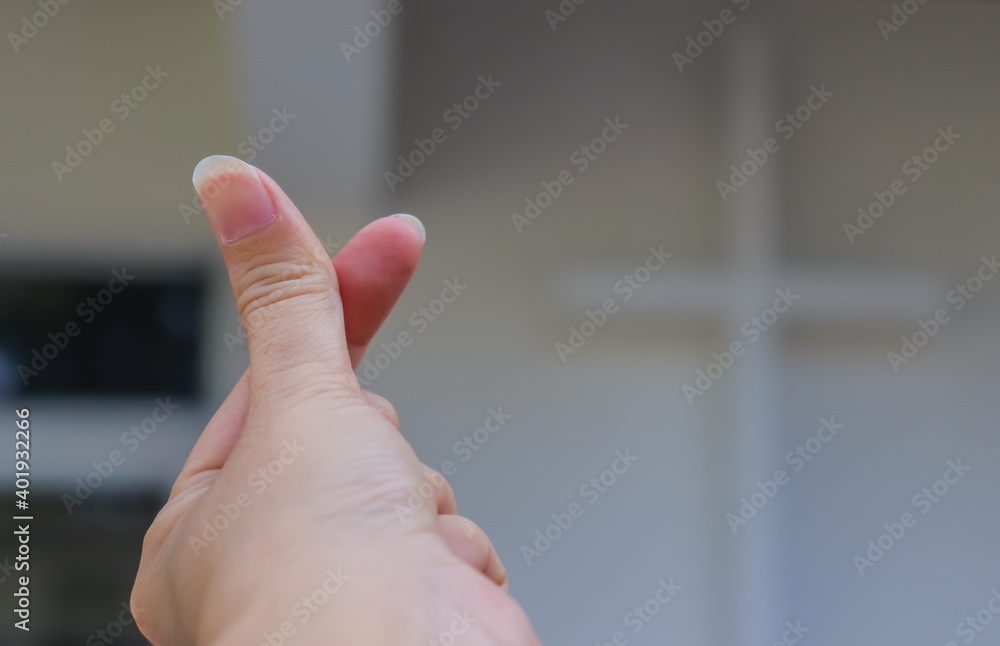 the-small-heart-gesture-with-blurry-cross-sign-background-the-finger