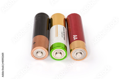 Different alkaline AA batteries on a white surface, close-up