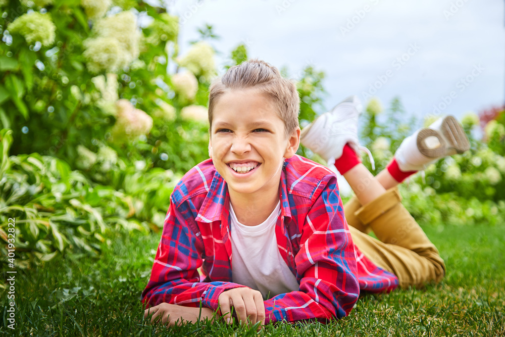 Young boy on the lawn with green grass and white flowers Young boy on the lawn with green grass and white flowers