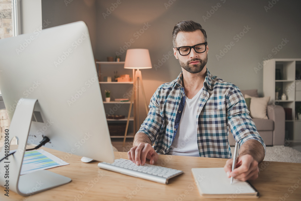 Photo of young handsome man serious concentrated write notebook plan to-do list distance work indoors Photo of young handsome man serious concentrated write notebook plan to-do list distance work indoors