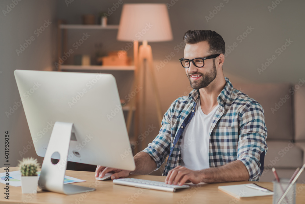 Photo of young cheerful handsome man happy positive smile remote work computer programmer desk indoors