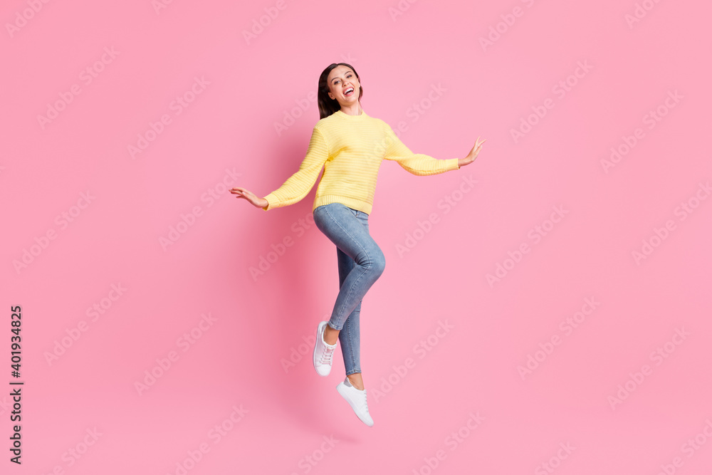 Full size photo of young beautiful happy smiling positive good mood girl jump fly isolated on pink color background Full size photo of young beautiful happy smiling positive good mood girl jump fly isolated on pink color background