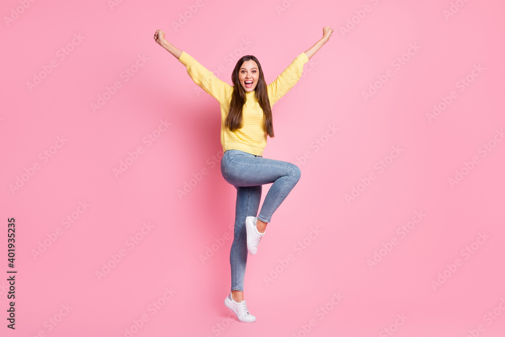 Full size photo of young beautiful crazy ecstatic positive good mood girl raise fists leg isolated on pink color background Full size photo of young beautiful crazy ecstatic positive good mood girl raise fists leg isolated on pink color background