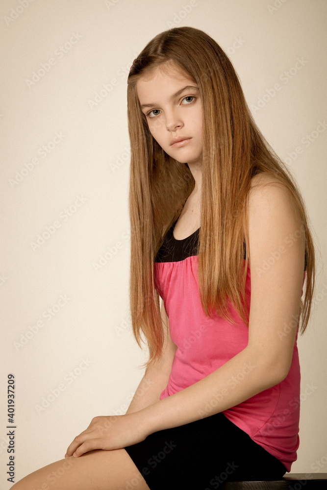 beautiful girl teenager in a pink blouse and black skirt posing in the studio beautiful girl teenager in a pink blouse and black skirt posing in the studio
