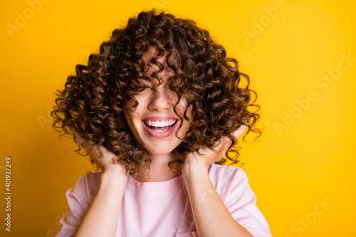 Slika na platnu Photo portrait of girl with curly hairstyle wearing t-shirt laughing touching ha