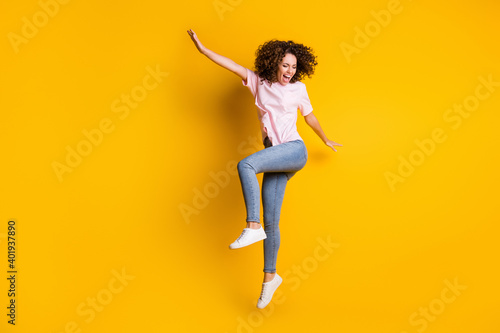 Photo portrait full body view of happy girl dancing jumping up isolated on vivid yellow colored background