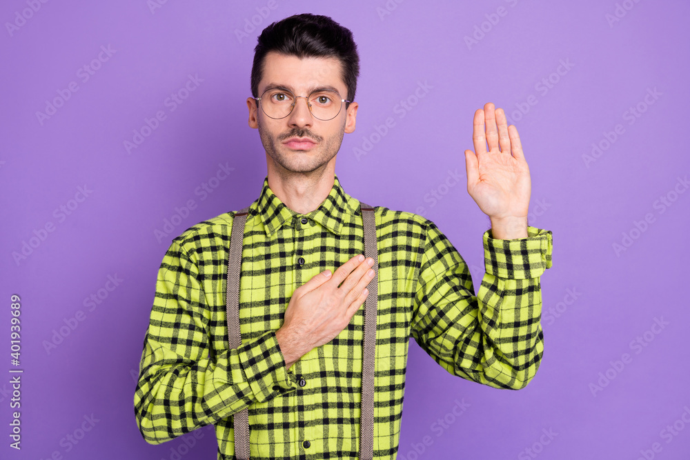 Photo portrait of man showing palm holding hand on heart giving oath isolated on vivid violet colored background Photo portrait of man showing palm holding hand on heart giving oath isolated on vivid violet colored background