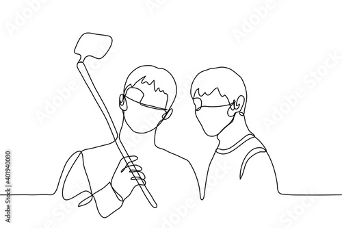two guys in masks take a selfie on a smartphone. one line of pictures two male friends posing and taking pictures of themselves, one of them holding a selfie stick with a phone