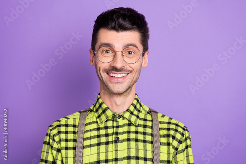 Photo portrait of smiling guy in glasses isolated on vivid violet colored background © deagreez