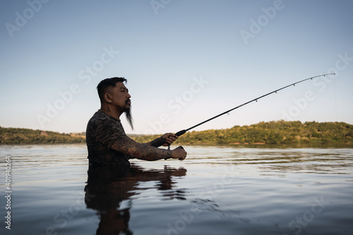 Young asian fisherman fishing on the river bank - Beautiful weather outdoors fishing at sunset.