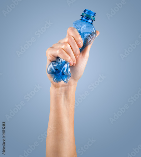female hand squeezes an empty plastic bottle