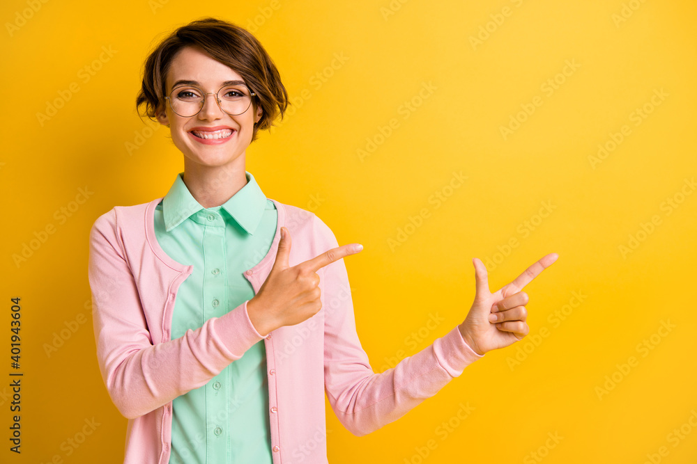 Photo of lady direct fingers empty space wear eyeglasses turquoise shirt pink cardigan isolated yellow color background Photo of lady direct fingers empty space wear eyeglasses turquoise shirt pink cardigan isolated yellow color background