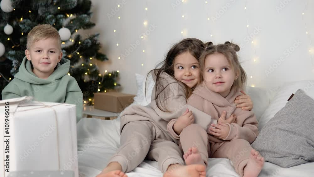 Children hugging near Christmas tree Children hugging near Christmas tree