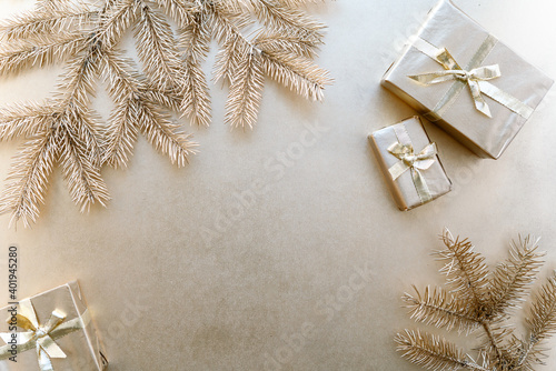 Golden Christmas or new year's background,plain composition of golden Christmas gifts and golden fir branches,Flatlay,empty space for greeting text.christmas concept.