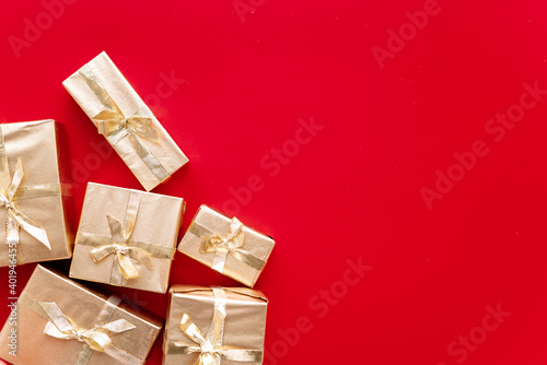 Red Christmas or new year's background, plain composition of golden Christmas gifts. Flatlay, empty space for greeting text.christmas concept. © Дарья Фомина
