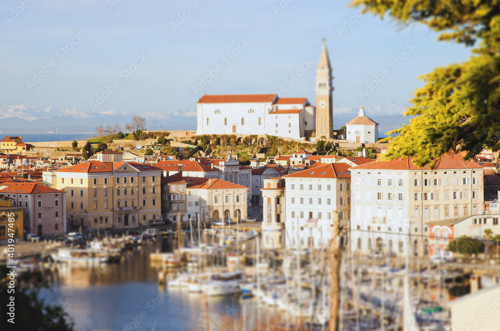 Obraz premium Red roofs of the historical center of old town Piran with main church against the sunset sky and Adriatic sea. Aerial view, Slovenia