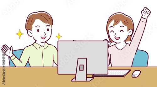 Two people talking while looking at a desktop computer