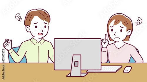 Two people talking while looking at a desktop computer