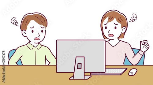 Two people talking while looking at a desktop computer