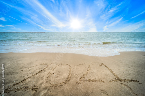 Fototapeta Naklejka Na Ścianę i Meble -  Happy New Year Numbers 2021 text on beautiful the sea beach with wave early morning sunrise over the horizon background.During Christmas and New Year.