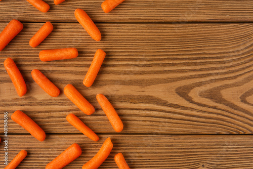 Small peeled pieces of carrot on textured wooden table. Top view. Copy space. © Grigoriy