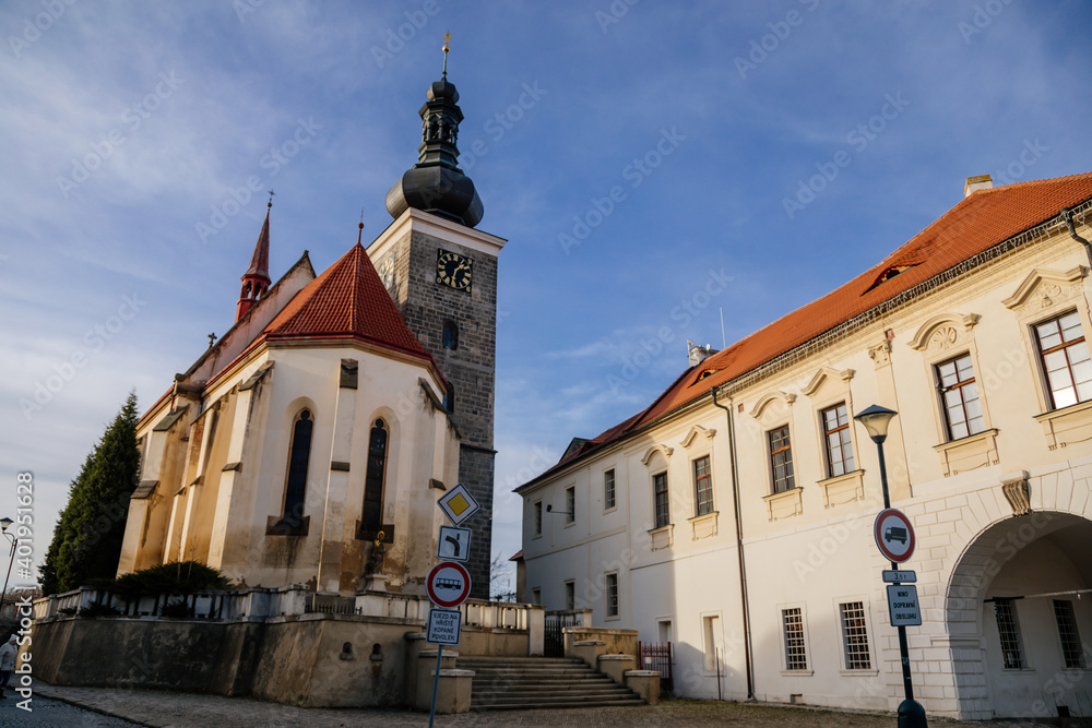 Gothic church of St. Catherine of Alexandria with bell tower at King Vladislav Square in medieval city Velvary in sunny winter day, Central Bohemia, Czech Republic