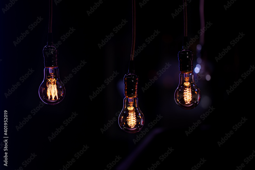 Three burning lamps on a blurred dark background. Three burning lamps on a blurred dark background.