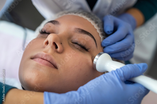 cosmetologist using ultrasound cavitation machine doing procedure lifting therapy massage