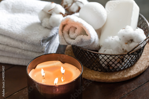 Spa composition with burning candles and bath accessories close up.