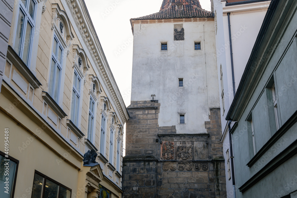 Gothic tower of the Velvary Gate, town fortifications built in the pre-Hussite period in sunny day, street of historic medieval city Slany, Central Bohemia, Czech Republic
