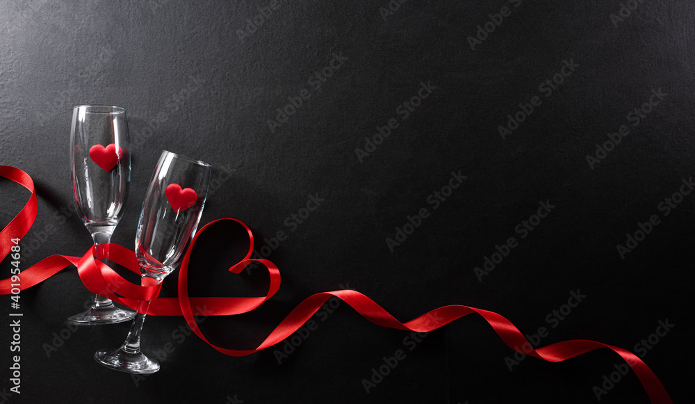 Valentine's day and love concept made from champagne glasses and red hearts on black wooden background. Top view with copy space, flat lay. - obrazy, fototapety, plakaty 